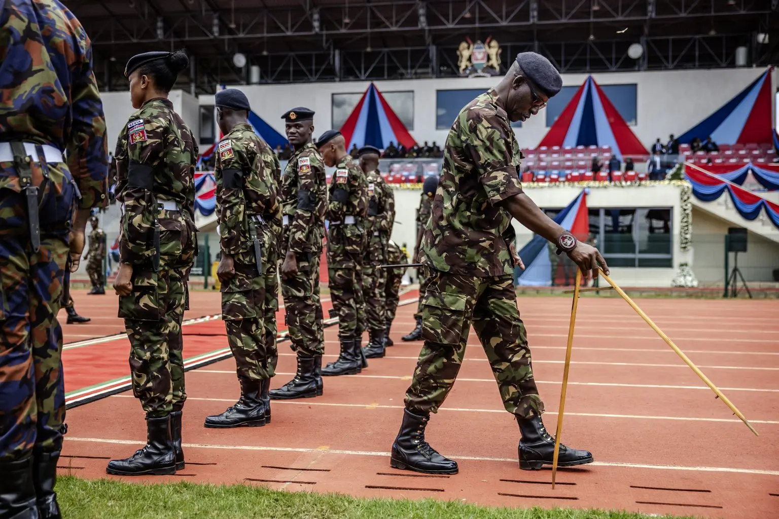 A senior member of the Kenyan Army uses a compass to mark the distance between soldiers in formation during a military honours ceremony in memory of the defence chief and nine other senior top military officers killed in a helicopter crash at the Ulinzi Sports Complex in Nairobi, on April 20, 2024. – Kenya began three days of mourning on April 19, 2024 followed by a series of military memorial ceremonies after its defence chief General Francis Omondi Ogolla and nine other senior top military officers were killed in a helicopter crash on April 18, 2024, in the latest accident to blight the nation’s military and shock the East African nation. (Photo by LUIS TATO / AFP)